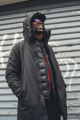 young african man standing in the street and looking further