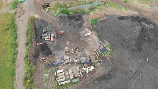 Leeds UK 26th August 2019: Aerial footage of a dumper truck being followered by the drone, then the dumper truck unloads the dirt and gravel from the truck into a pile for recycling.