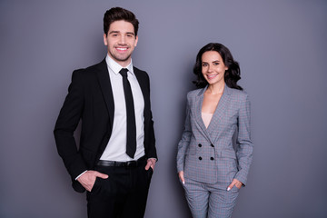 Portrait of beautiful man and woman with wavy curly brunette hair wearing black tuxedo jacket...