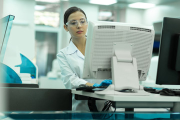 Thoughtful scientist looking at screen of computer