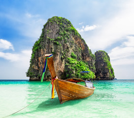 Thai traditional wooden longtail boat and beautiful sand beach.