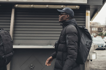 young black man walking in the street and looking further