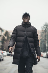 young bearded african man outdoors walking looking camera