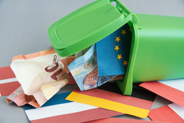 Eurozone crisis concept, flags of the countries of the European Union, euro banknotes in the garbage can 