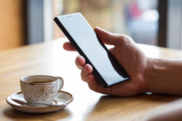 Close up of man's hands holding mobile smart phone.