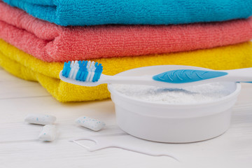 Toothbrush, cleaning powder, dental floss and towels. Dental care products in bathroom. Keep your teeth clean.