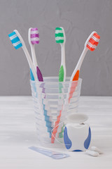 Toothbrush in glass, dental floss and chewing gums. Dentistry and health care concept.
