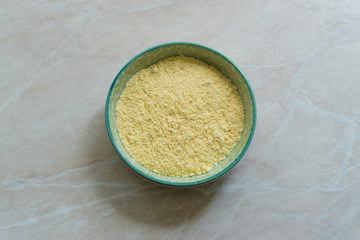 Dry Organic Corn Meal Flour in Ceramic Bowl.