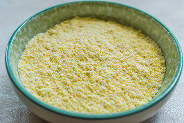 Dry Organic Corn Meal Flour in Ceramic Bowl.