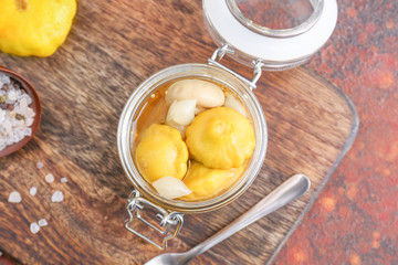 Jar with canned squashes on wooden board