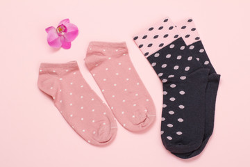 Two pairs of women socks on pink background.