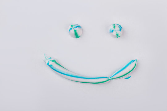 Toothpaste In A Shape Of Face With Smile. Smiling Emoji Face With Colorful Toothpaste. Tooth Cleaning Concept.