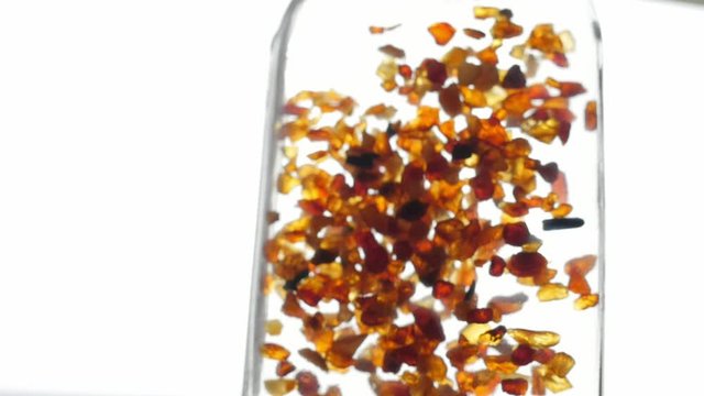 pieces of amber in water falling to the bottom slow motion