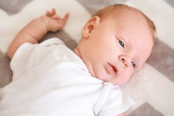 Cute little baby lying on bed