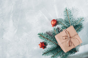 Christmas background. Gift box with a sprig of a Christmas tree on a gray background