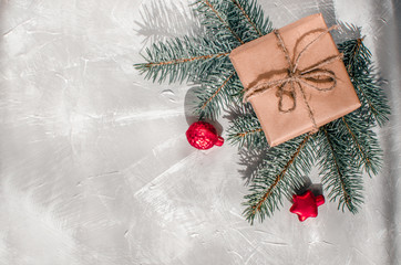 Christmas background. Gift box with a sprig of a Christmas tree on a gray background