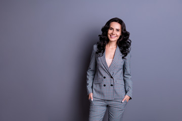 Portraut of beautiful woman with beaming smile standing wearing gray suit trousers pants isolated over gray background