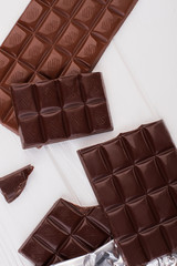 Chocolate bar on white background, top view. Pieces of dark and milk chocolate bar.