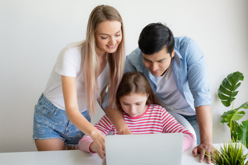 mother, father advise daughter for using laptop computer at home together at home, young family concept