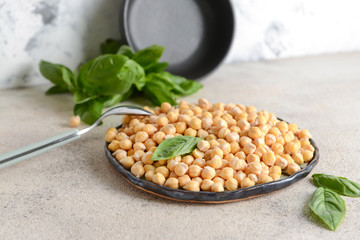 Plate with raw chickpea on table