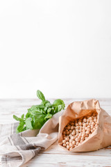 Paper bag with raw chickpea on table