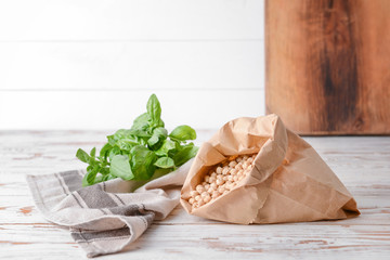 Paper bag with raw chickpea on table