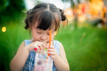 Asian little girl drinking juice