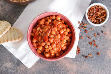 Bowl with tasty chickpea in tomato sauce on table