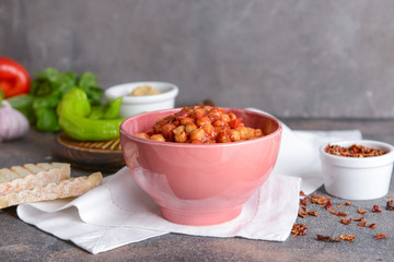 Bowl with tasty chickpea in tomato sauce on table