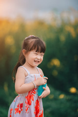 Happy little asian girl in flower field