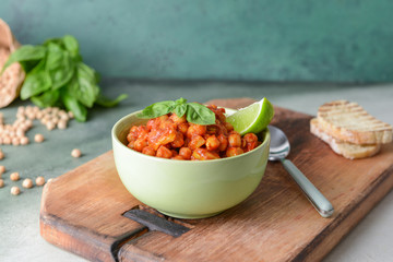 Bowl with tasty chickpea in tomato sauce on table
