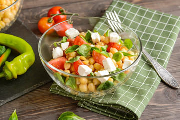 Bowl with tasty chickpea salad on table