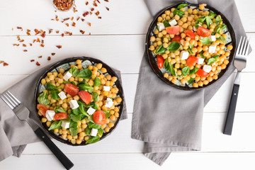 Plates with tasty chickpea salad on table