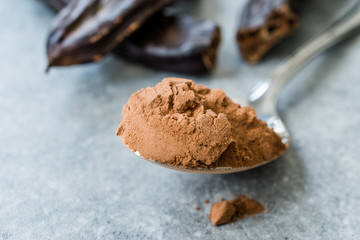 Carob Powder and Pods Ready to Use in Spoon