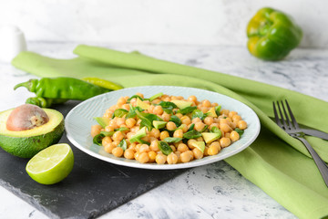 Plate with tasty chickpea salad on table