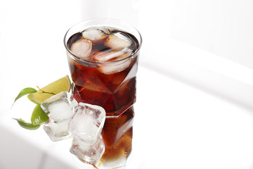 Glass of cold cola on table