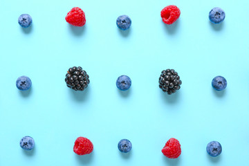 Many sweet ripe berries on color background