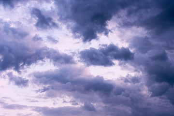 Blue hour sky clouds background. Beautiful landscape with stormy clouds and purple sun on sky