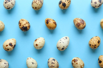 Many quail eggs on color background