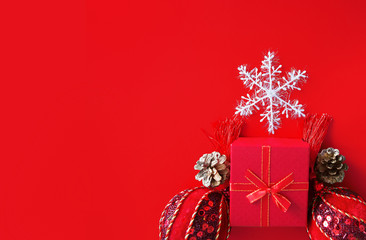 Decorative white snowflake, red present box, golden cones and shiny derative balls