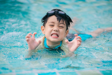 Fototapeta na wymiar Fun boy in swimming pool