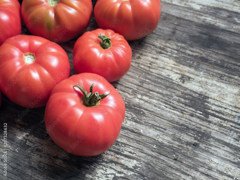 Wall mural healthy vegetables. close up fresh ripe red farm ugly tomatoes on a grey wooden background. flat lay