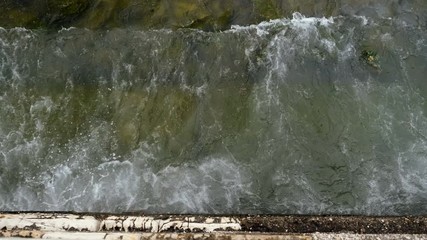 Seascape. Top view of sea waves breaking on rocky beach of Mediterranean coastline. Greece. 4K