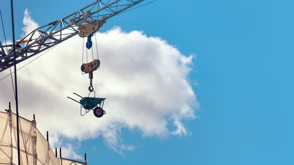 Crane moving working tools. Bottom view of construction site with machinery at work (copy space...