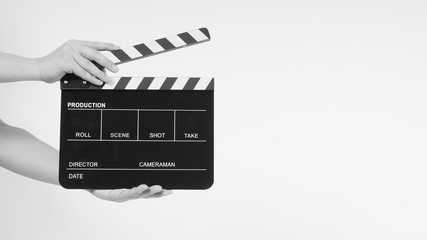 A man's hands is holding black Clapperboard or movie slate. it use in video production ,film, cinema industry.It is white background.