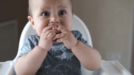 Little baby eating kids homemade cookies himself and smiling. Slow motion