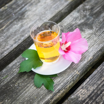 Mallow tea with blossom on old wooden background