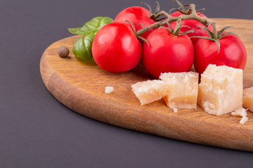 Pieces of Rigiano parmesan, cherry tomato and basil leaf