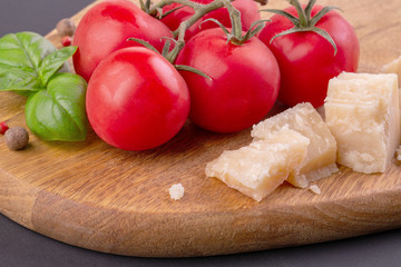 Pieces of Rigiano parmesan, cherry tomato and basil leaf