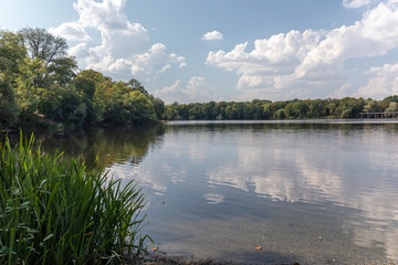 View of the popular lake Auensee in the north of Leipzig with old bridge and miniature railway